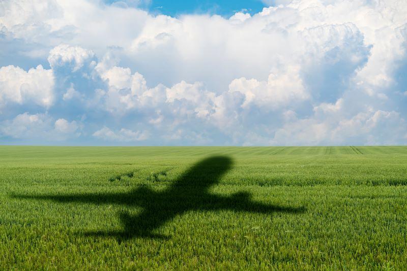 airplane over green field