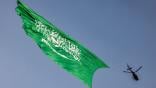 A helicopter flies over with a giant Saudi flag during an air show marking Saudi Arabia's 93rd National Day celebrations in Riyadh 