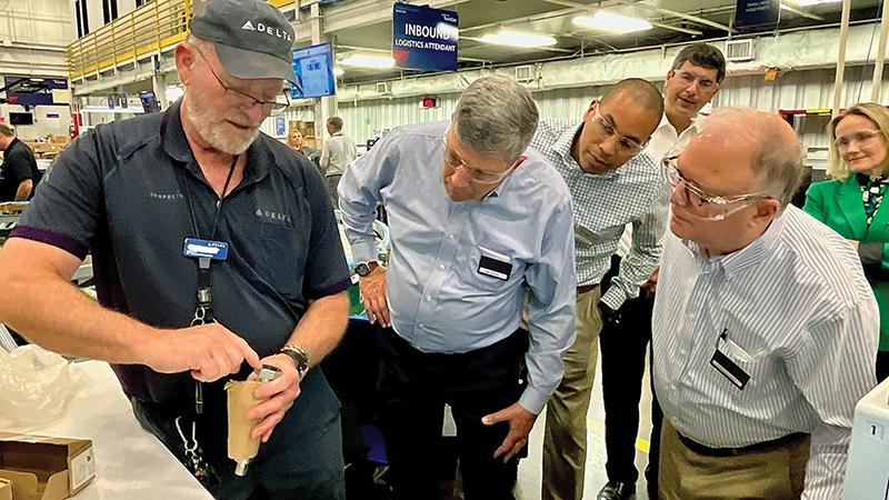 employees looking at an aircraft part