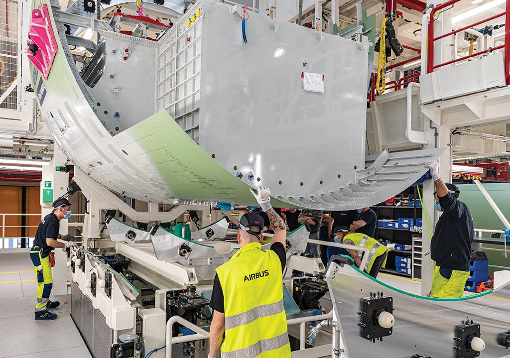 Airbus employees examining aircraft parts 